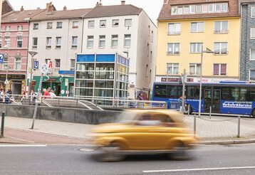Kölner Straße in Düsseldorf-Oberbilk, ein Auto fährt mit Bewegungsunschärfe durchs Bild
