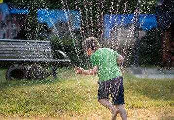 Sommerfest im Oberschlesischen Landesmuseum ein Junge spielt mit dem Wasserschlauch