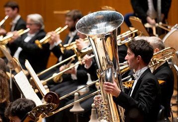 Orchester, im Vordergrund ein Tubaspieler