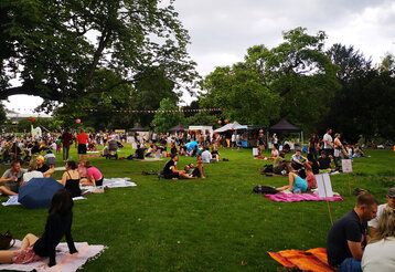 Leute sitzen auf Picknickdecken in einem Park