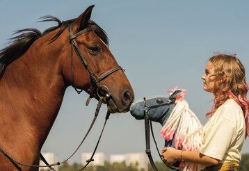 Szene aus dem Film Pferd am Stiel, ein Mädchen mit einem Steckenpferd steht einem echten Pferd gegenüber
