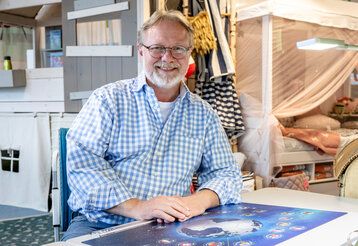 Porträt von Klaus Maiwald, der in seinem Geschäft an einem Schreibtisch sitzt