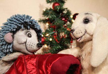 Szenenbild mit Hasen- und Igelpuppe vor einem Weihnachtsbaum aus „Mein Weihnachtsgeschenk für dich“ des August Theaters Dresden.