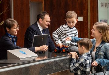 Mutter mit zwei Kindern an der Rezeption im Maritim Travemünde