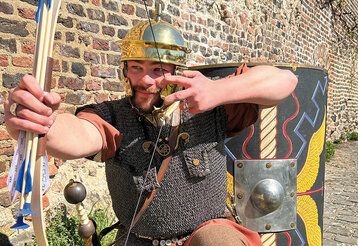 Ritter mit Pfeilund Bogen vor alter Mauer