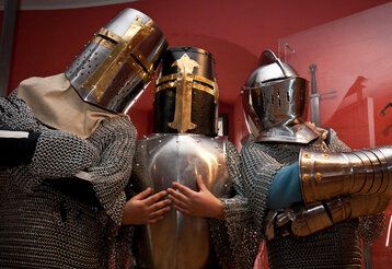 drei Personen posieren in Ritterrüstungen im Kindermuseum Adlerturm