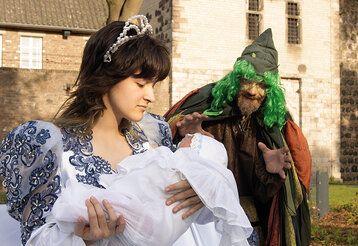 ein Schauspieler und eine Schauspielerin stellen eine Szene aus dem Märchen Rumpelstilzchen nach