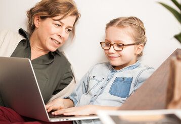 Mutter mit Kind vor Laptop