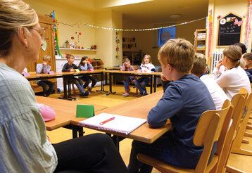 das Schülerparlament der Grundschule sitzt in einem Klassenraum zusammen