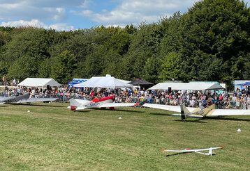 Segelflugzeuge auf der Wiese des Düsseldorfer Aero-Klubs beim Flugplatzfest, mit Publikum und Ständen