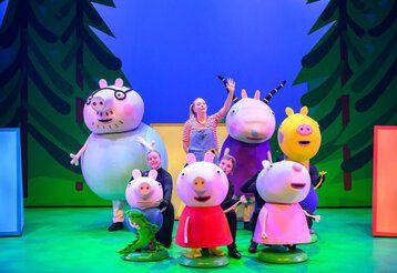 Bühnenszene aus Peppa Wutz mit der ganzen Familie Wutz und den Puppenspielern