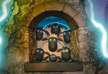 Szene aus dem Film Shaun das Schaf Spuk im Kürbisfeld, sieben Schafe gucken aus dem Fenster einer Burg heraus, umringt von Blitzen