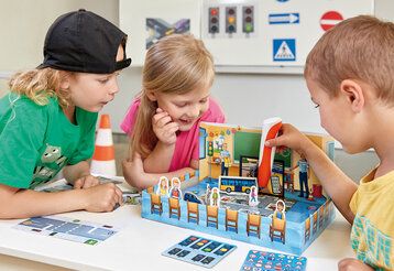 Drei Kinder spielen das Tiptoi-Spiel „Sicher durch den Straßenverkehr“