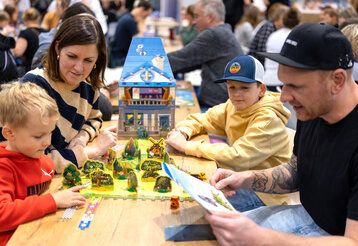 Familie spielt auf der Messe Spiel Essen ein Gesellschaftsspiel