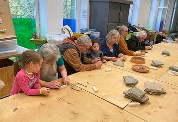 Steinzeitatelier Ton im Neanderthal Museum, Senior:innen und Kinder werkeln gemeinsam