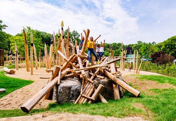 Kinder stehen auf einem Klettergerüst des Steinzeitspielplatz beim Neanderthal Museum