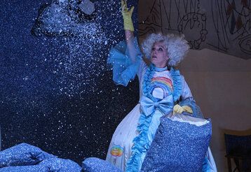 Szene aus der Oper Holle!, eine Frau wirft Glitzer in die Luft