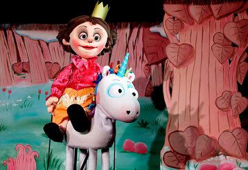 Szene aus dem Puppentheaterstück Das Neinhorn, eine Prinzessin reitet au dem Neinhorn