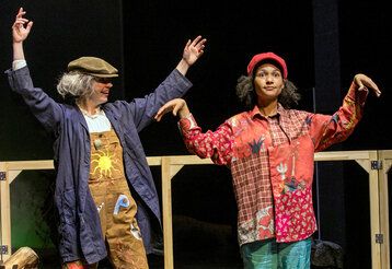 Zwei Schauspielerinnen auf der Bühne, eine in Marionettenhaltung