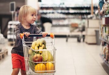 Kind schiebt einen Einkaufswagen