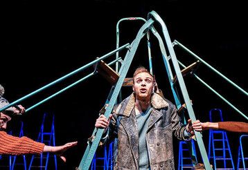 Schauspieler steht auf der Bühne, unter einer Leiter