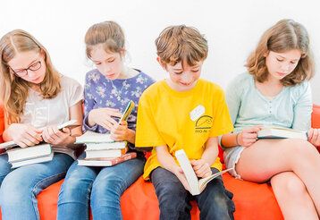 Lesende Kinder auf einer Couch
