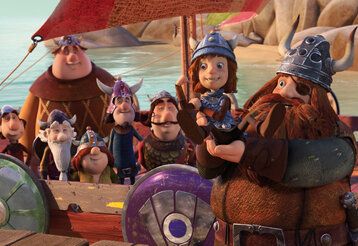 Animationsfilm, Wickie ist auf dem Arm seines Vaters und befühlt seine Armmuskeln, im Hintergrund due starken Männer auf dem Wickingerschiff