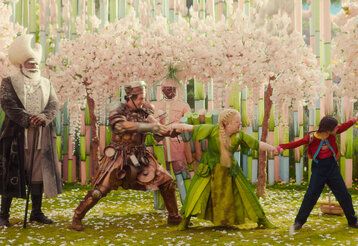 Szene aus dem Film Der Wunderweltenbaum, verschiedene Personen stehen in einer Art Märchenwald