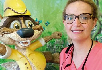 Zahnärztin Anna Katharina Kreienkamp mit lustiger Biberfigur vor grüner Wand