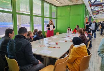 Jugenliche und Kinder sitzen zusammen an einem Tisch bei der COMIC UND MANGA-CON DÜSSELDORF
