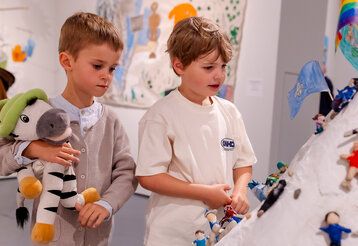 Zwei Jungs besuchen die Kleine und betrachten ein Kunstwerk