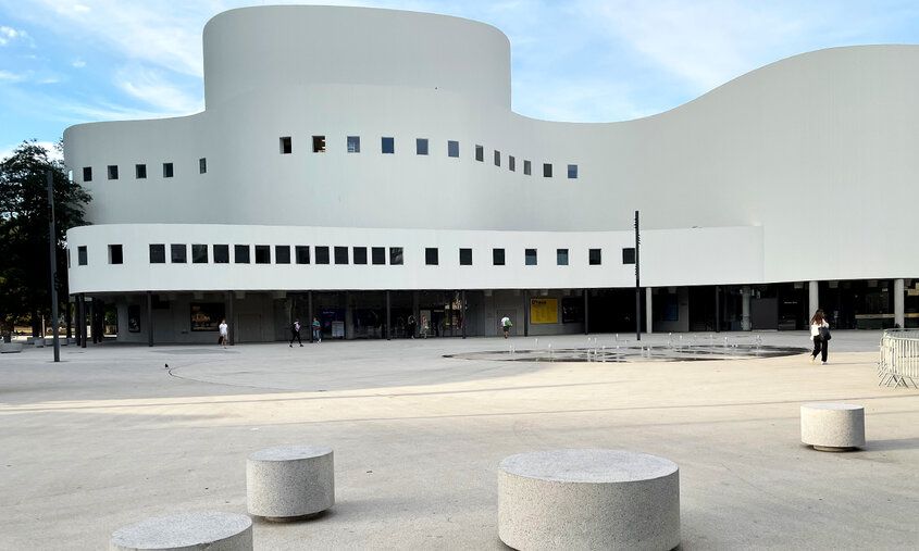 weißes geschwungenes Gebäude mit Platz davor