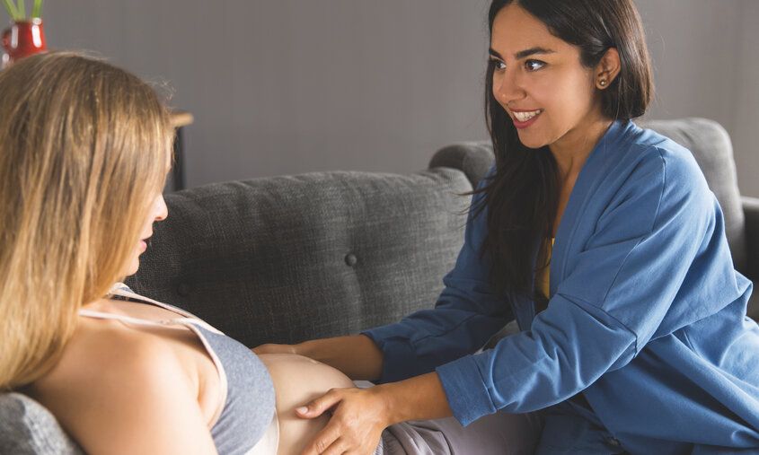 Hebamme fühlt Schwangeren den Bauch