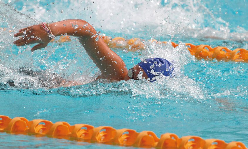 Schwimmer krault durch ein Schwimmbecken