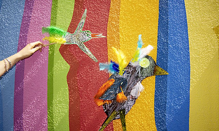 gebastelte Papiervögel vor bunter Wand