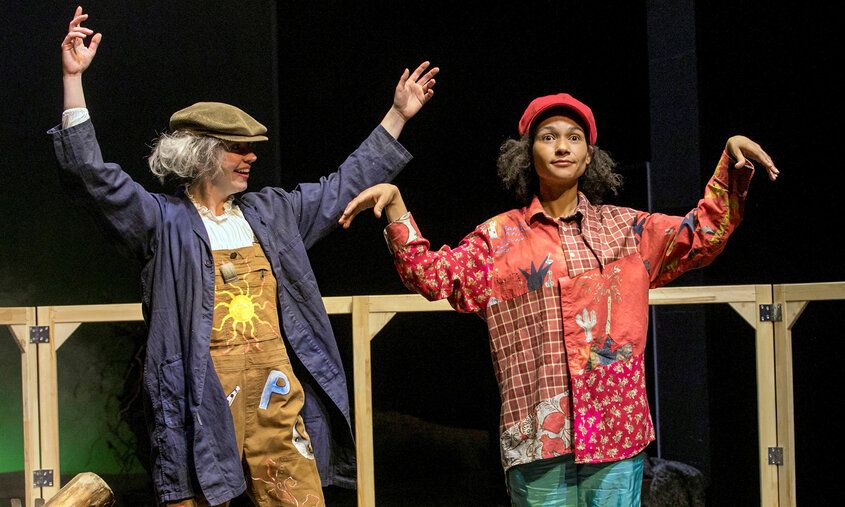 Zwei Schauspielerinnen auf der Bühne, eine in Marionettenhaltung