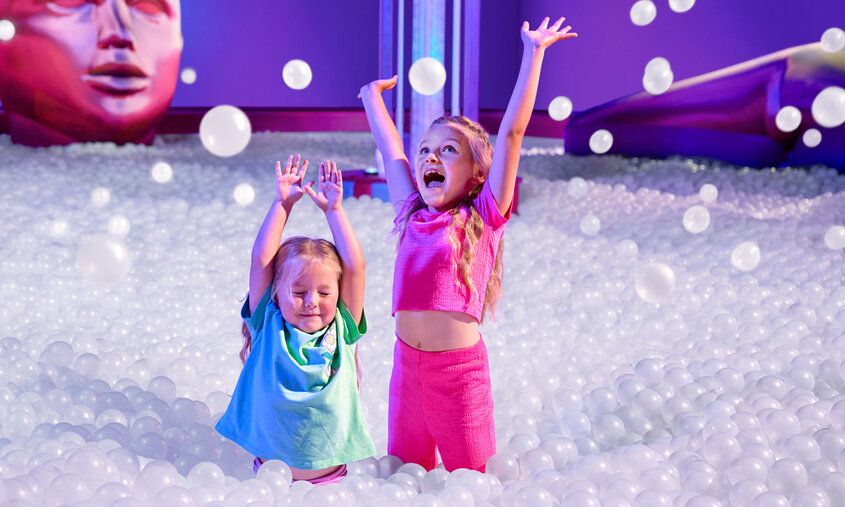 Zwei Mädchen toben in einem Bällebad bei Bubble Planet