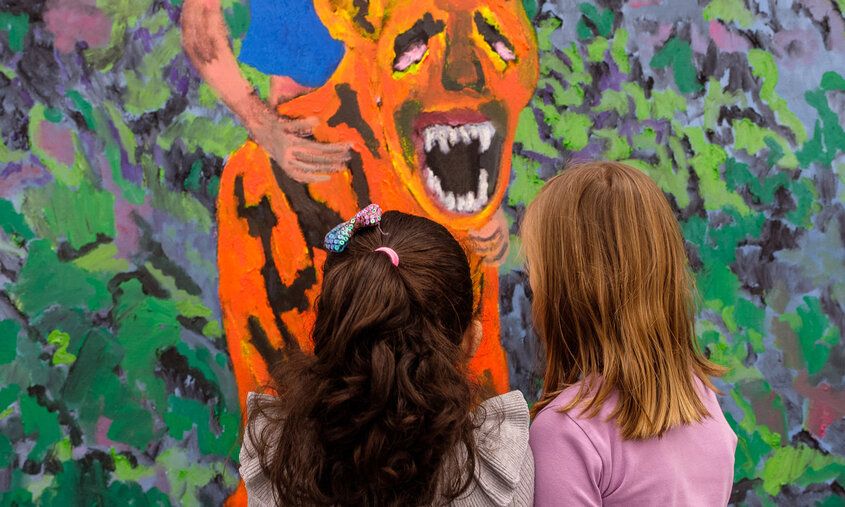 Zwei Mädchen vor einem Ölgemälde, auf dem ein Tiger abgebildet ist