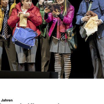 Fünf junge Schauspieler in „Das flegende Klassenzimmer“ schauen gebannt auf ein aufgeschlagenes Buch.